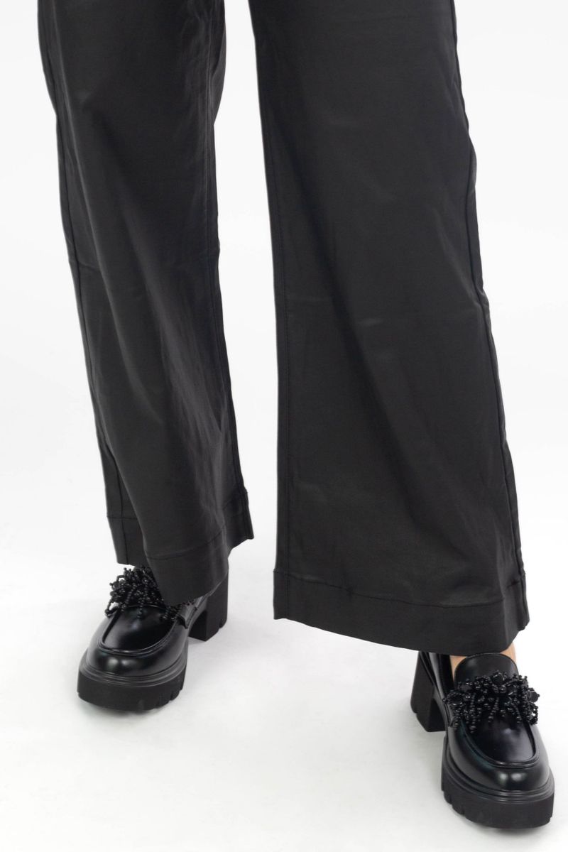 Coated trousers with an exhibited leg